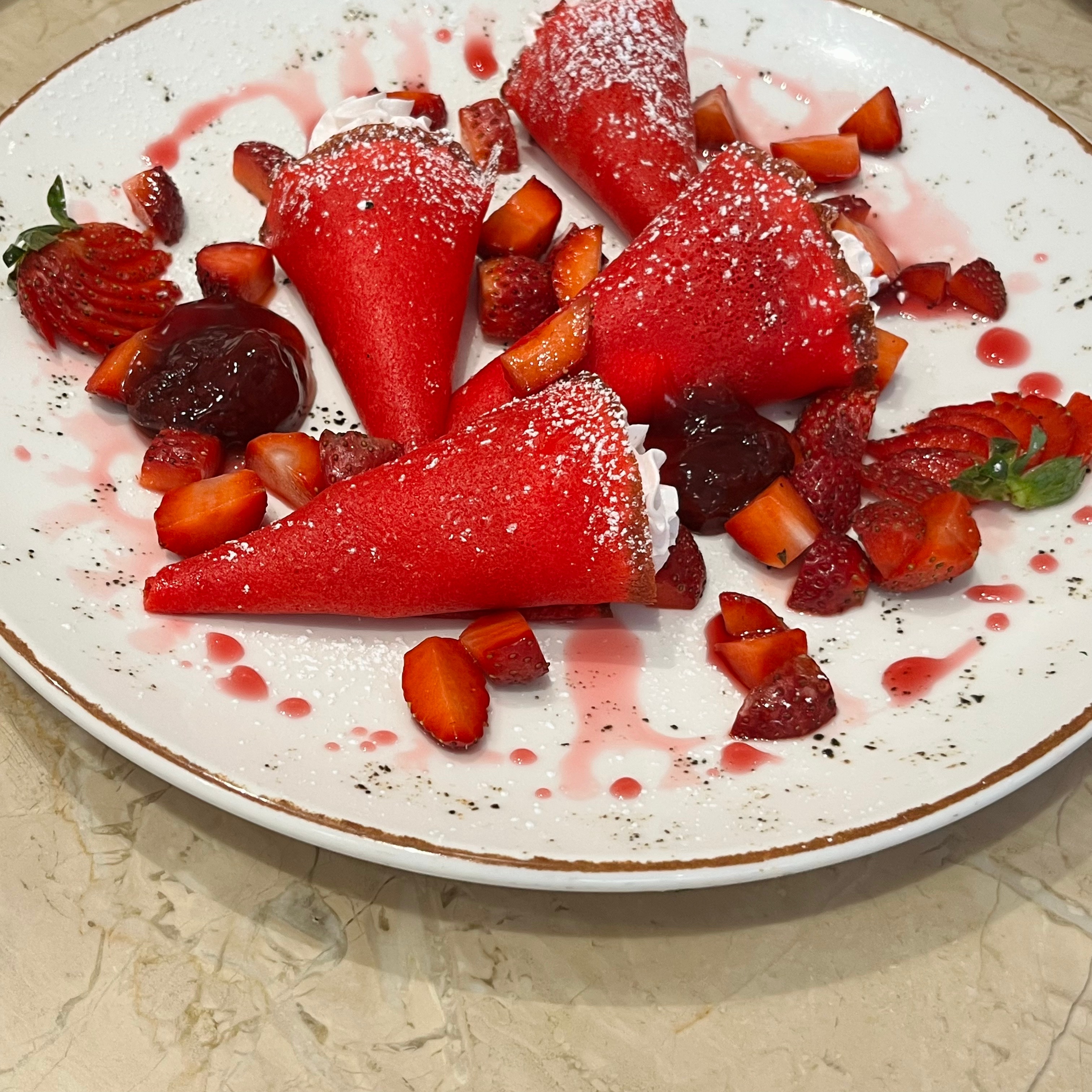 Cone-shaped strawberry crepes, filled with strawberry mascarpone and drizzled with strawberry sauce.